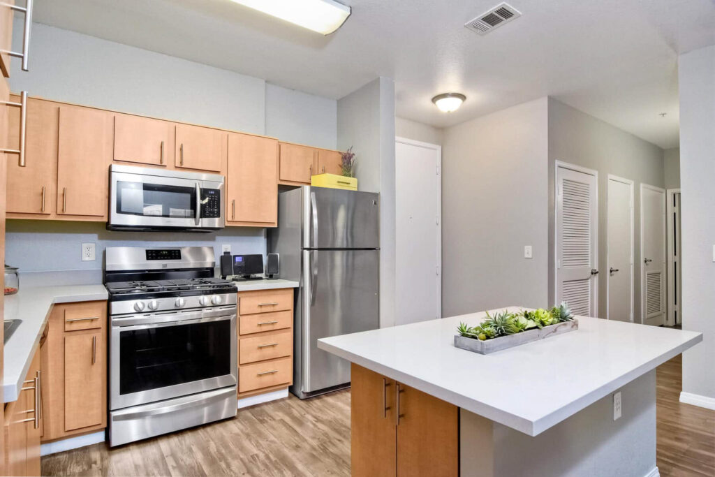 Apartment kitchen with wood cabinets and stainless steel appliances