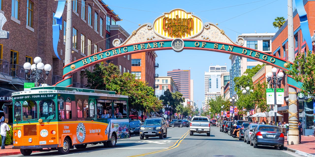 Street view of Gaslamp Quarter with cars and a sign over it